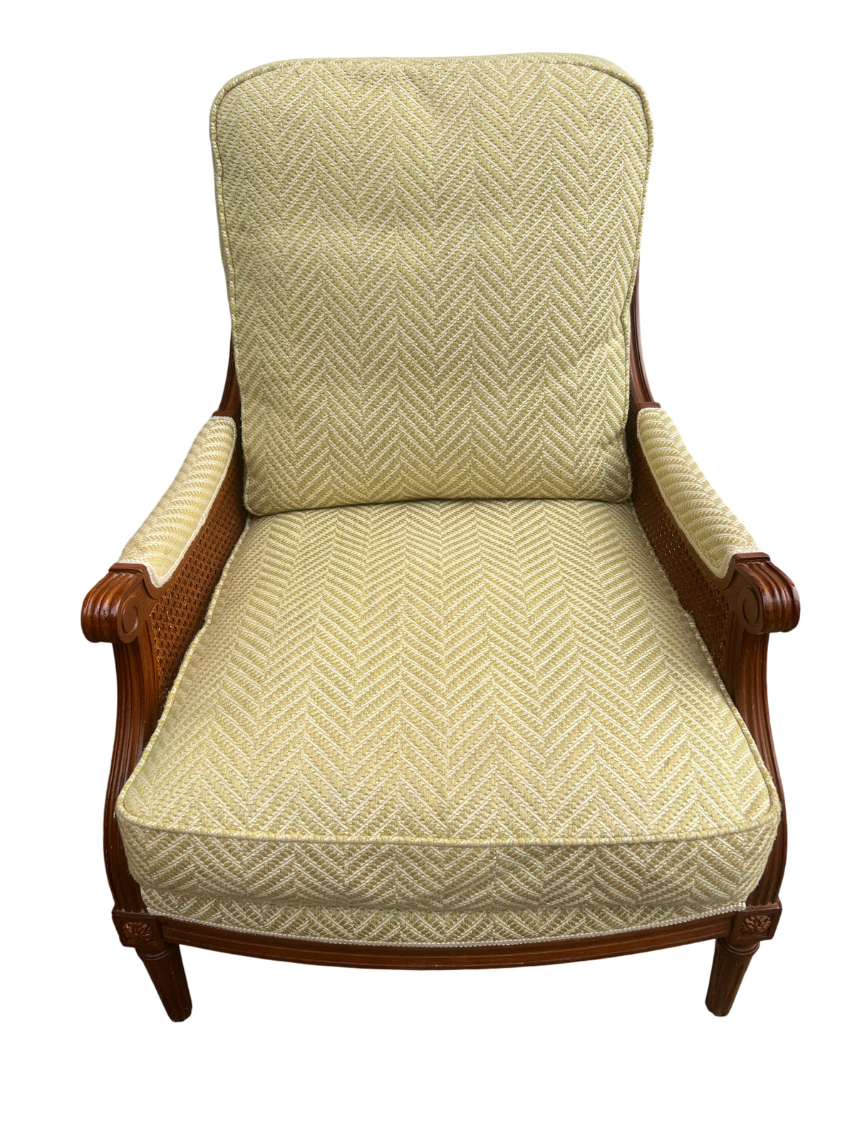 Vintage cane armchair with carved wood frame and pale yellow upholstered seat and back