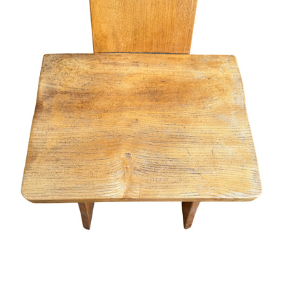 Four wooden kitchen chairs in oak finish arranged outdoors