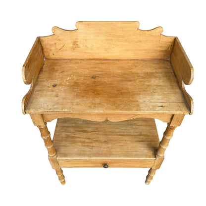 Close-up of shaped gallery back and scrolled side panels on pine bedside table