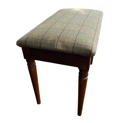 Side view of vintage tweed bench showing padded seat and wooden apron