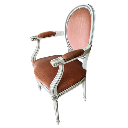 Front view of vintage upholstered armchair with peach velvet seat and decorative nailhead trim