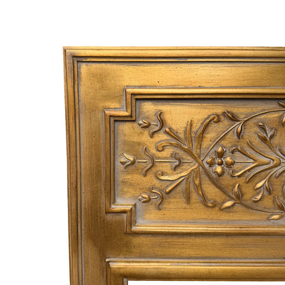 Angled view of large gold wall mirror showing moulded frame and bevelled edge
