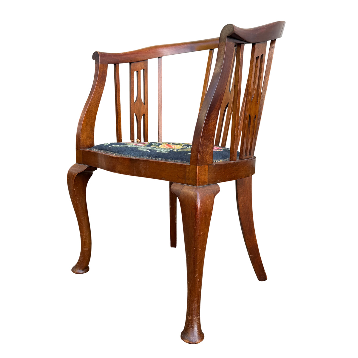 Curved top rail and vertical slats on Arts & Crafts wooden armchair with needlepoint seat