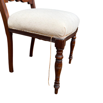 Side view of Edwardian upholstered dining chair showing carved back and seat profile