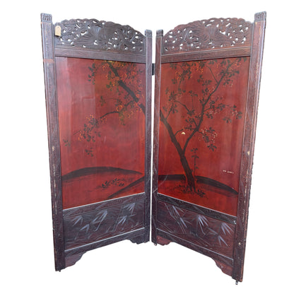 Worn lacquer surface detail on black panel of two-panel folding screen