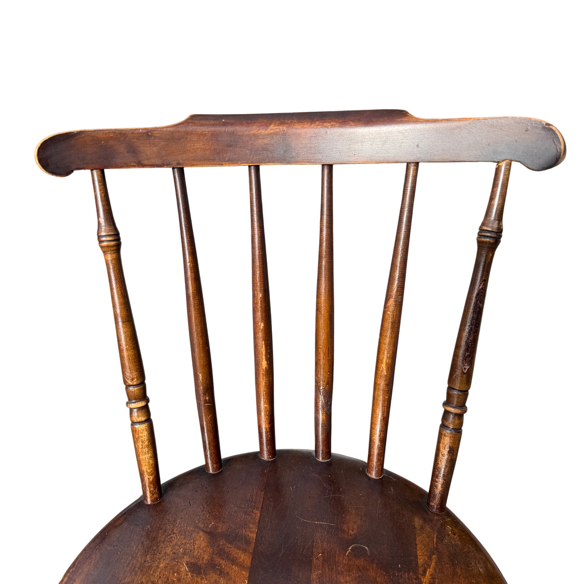 Rear view of spindle stick back and top rail with worn edges on a penny-seat chair
