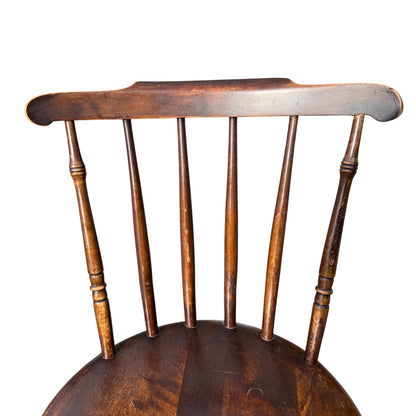 Rear view of spindle stick back and top rail with worn edges on a penny-seat chair