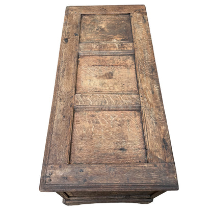 Carved oak chest corner showing carved leg and decorative panel