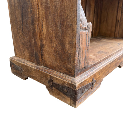 Full height view of tall rustic carved oak bookcase outdoors