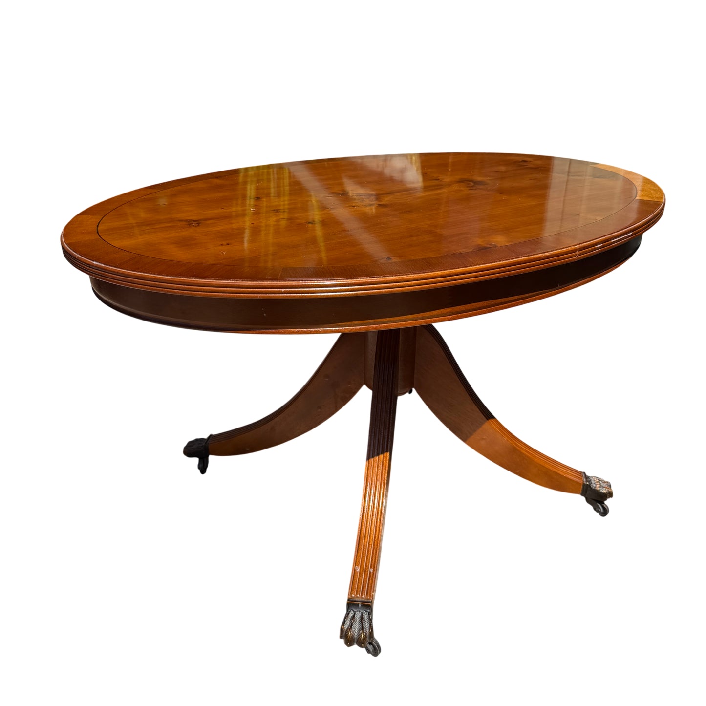 Vintage oval pedestal dining table with warm mahogany finish and splayed base with castors