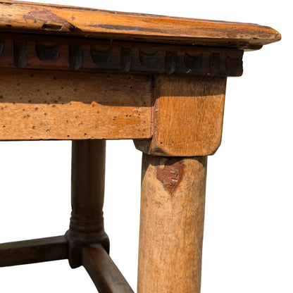 Detail of oak apron with small historic wormholes on a Victorian coffee table