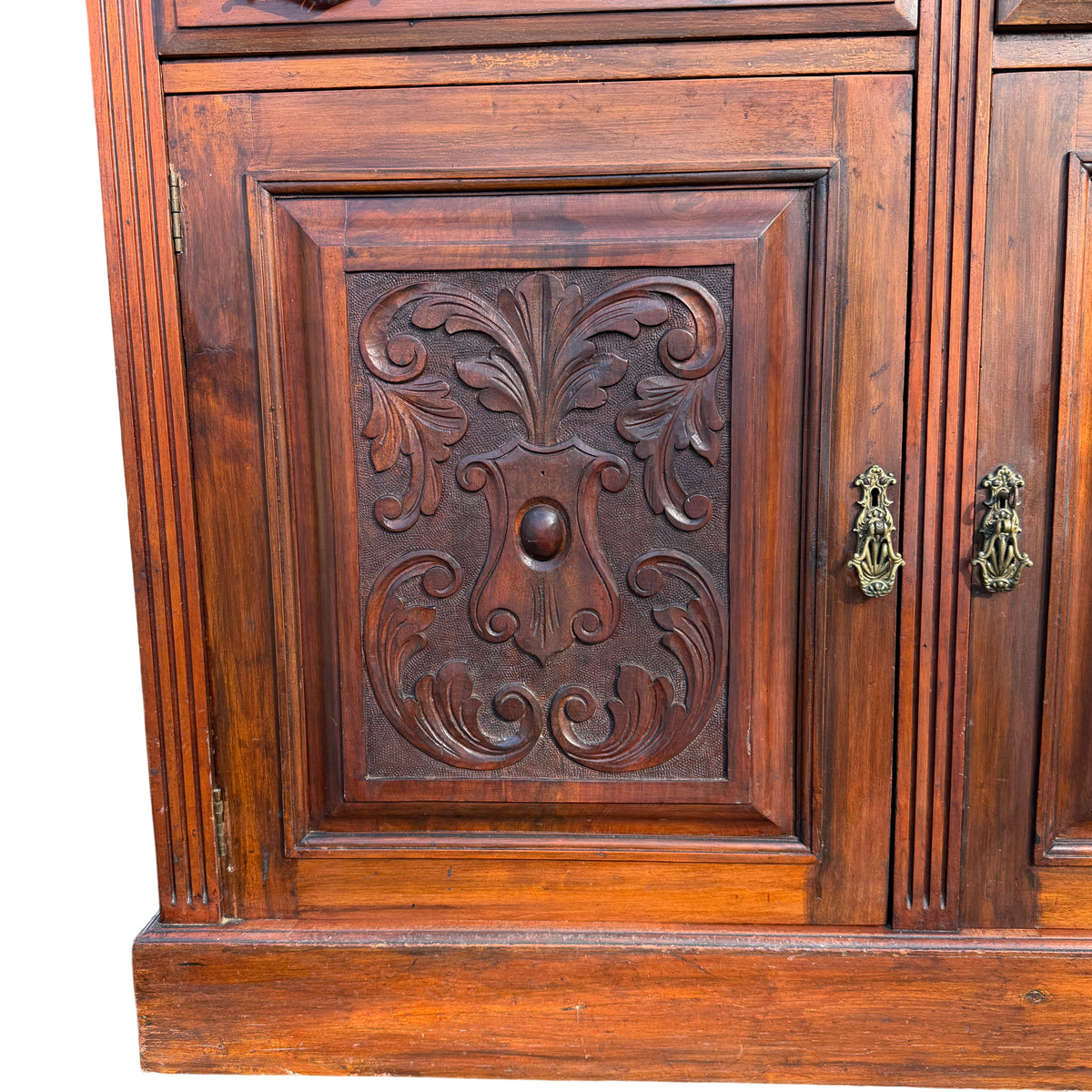 Left side panel and corner of a carved wooden Victorian sideboard