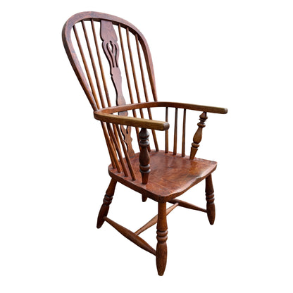 Side angle of Windsor-style oak armchair with turned arm supports and legs
