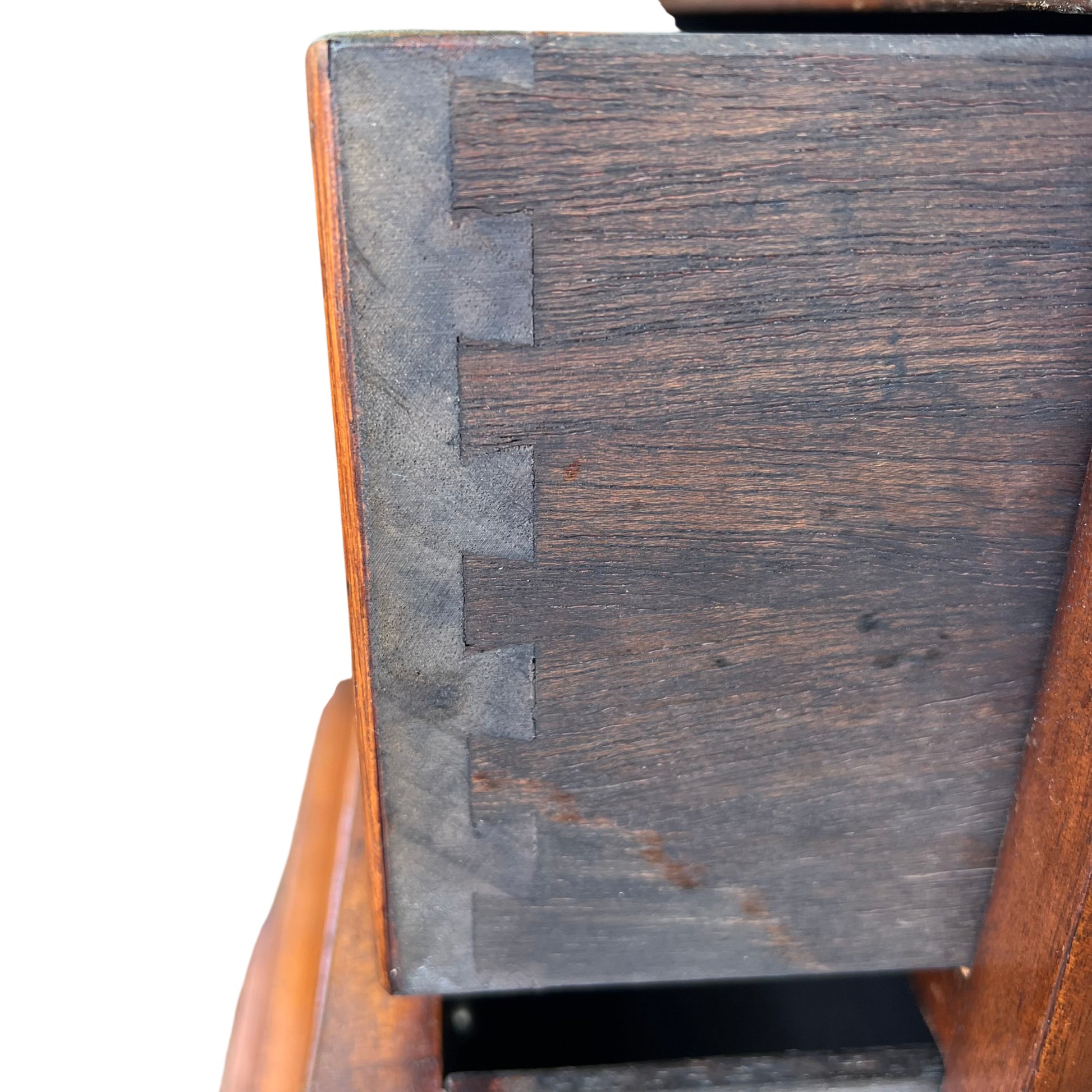 Close-up of brass drop handle and decorative escutcheon on drawer front