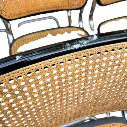 Top-down view of cane backrests and chrome tubular cantilever frames of Italian dining chairs