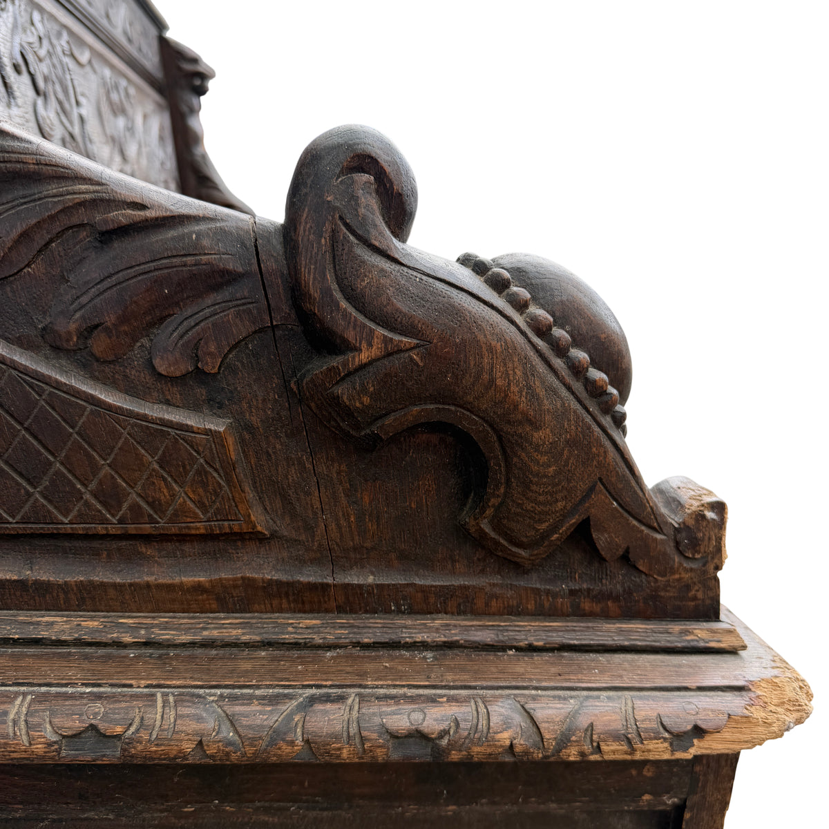 Close detail of scuffed and worn edge of carved oak armrest