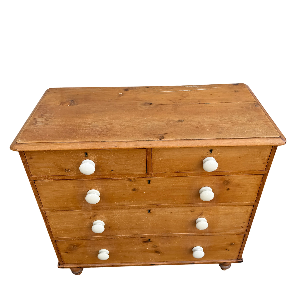 Close-up of ceramic drawer knob on pine chest of drawers