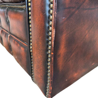 Side profile of Chesterfield leather armchair showing heavy frame and rolled arm