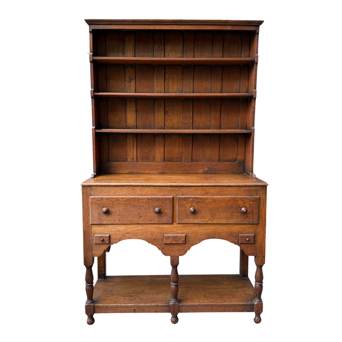 Front view of oak Welsh dresser with panelled back and multiple open shelves