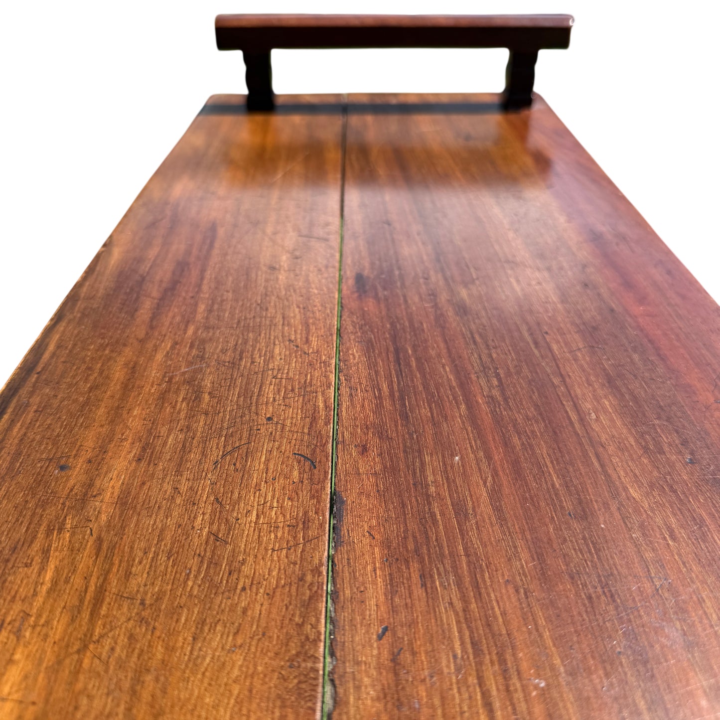 Under-edge detail of mahogany table showing moulding profile and edge chips
