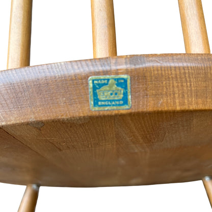 Side view of vintage wooden rocking chair arm and spindle back in light wood