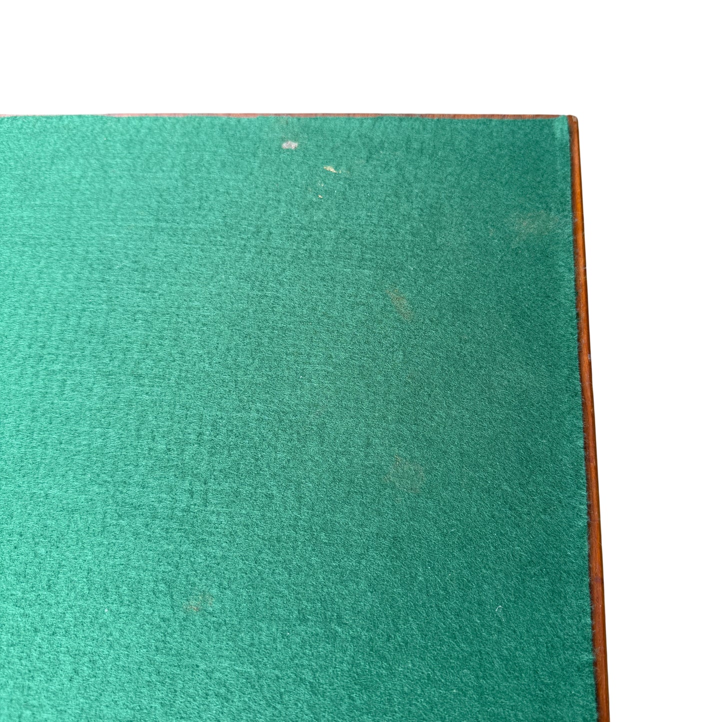 Edge detail of wooden folding card table with small chips and finish wear