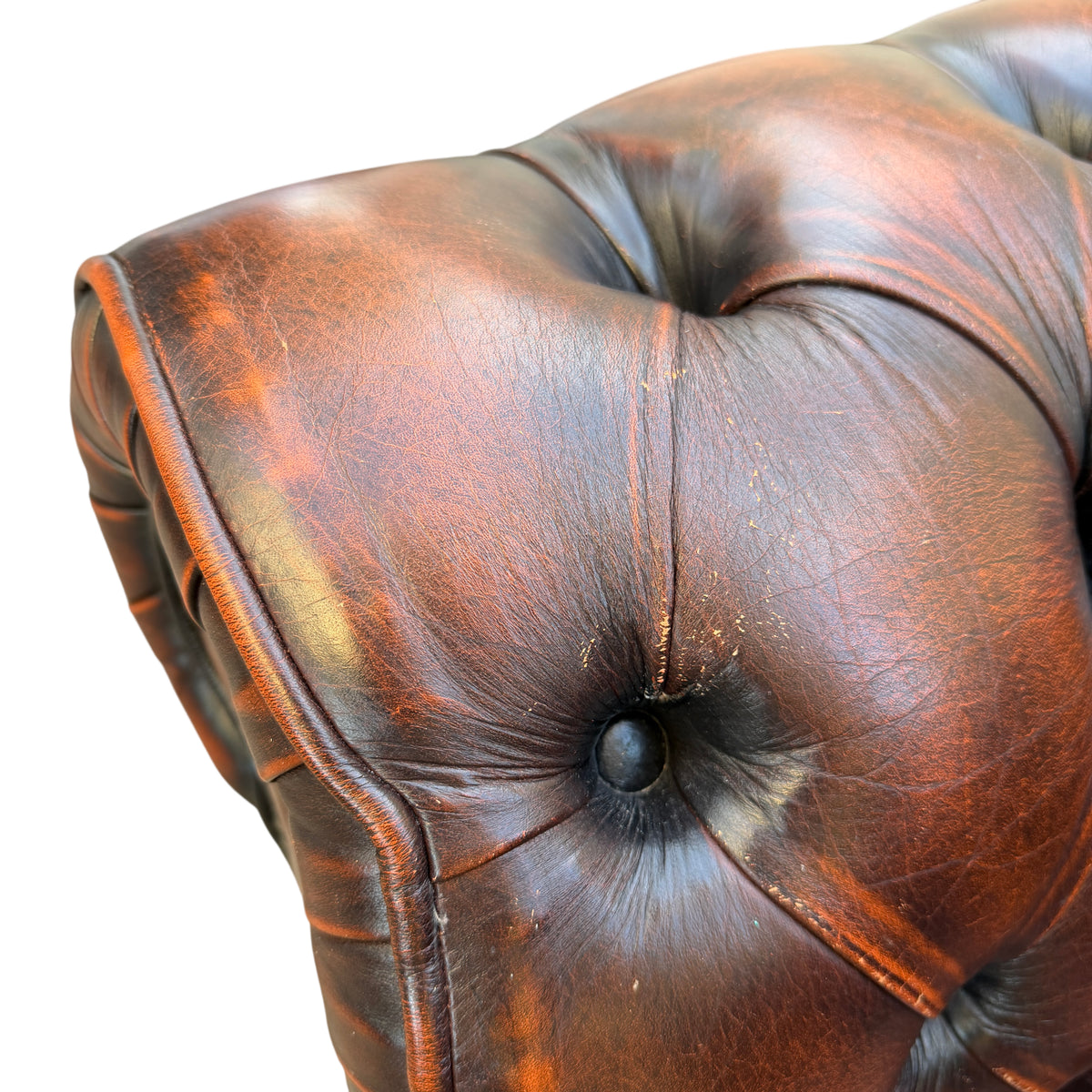 Top-down view of button tufted seat and back of brown leather Chesterfield chair