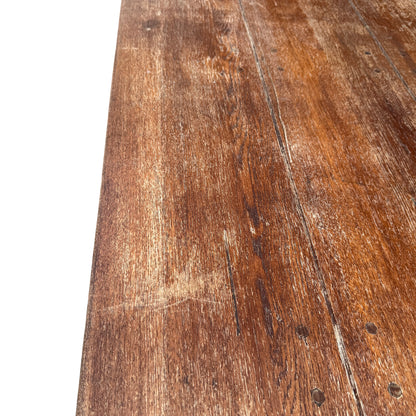 Edge detail of vintage oak dining table showing worn finish and scratches