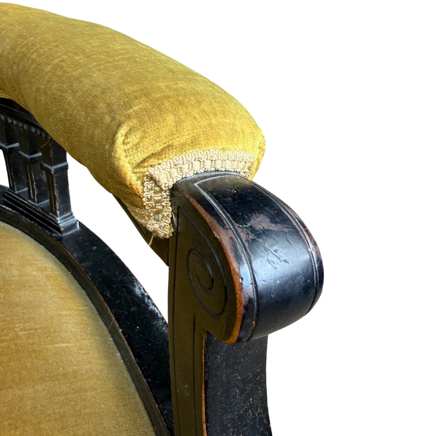Front view of Victorian upholstered armchair showing curved back and open base with spindles