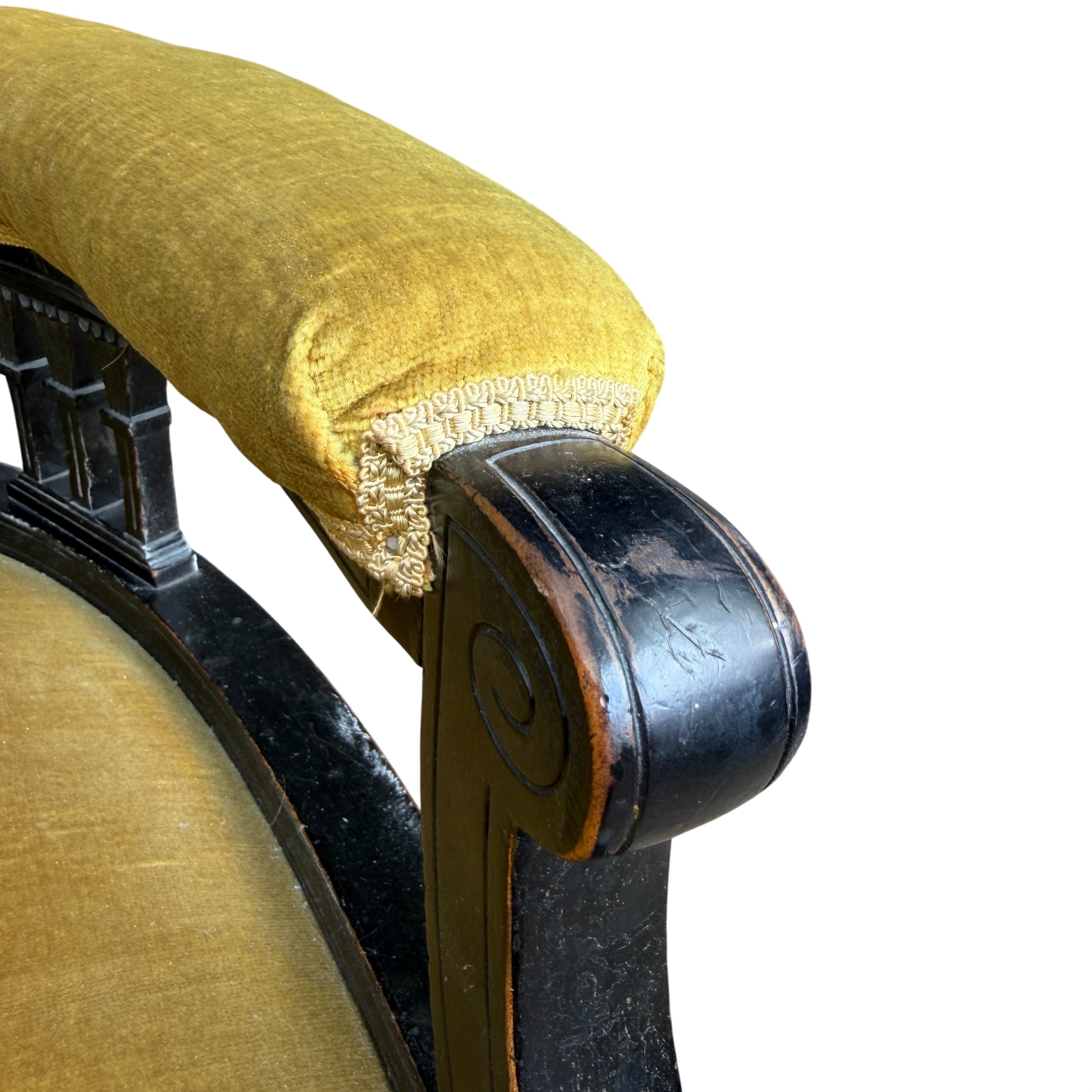 Front view of Victorian upholstered armchair showing curved back and open base with spindles