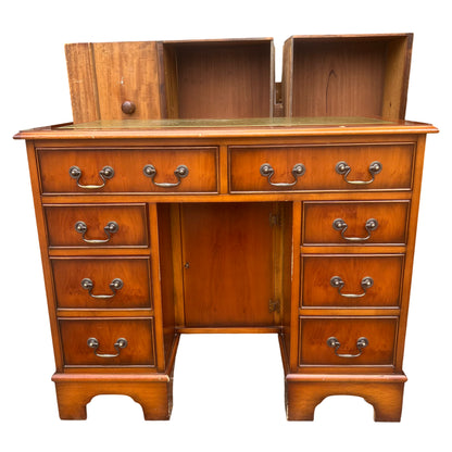 Front view vintage wooden kneehole desk with brass-effect drop handles