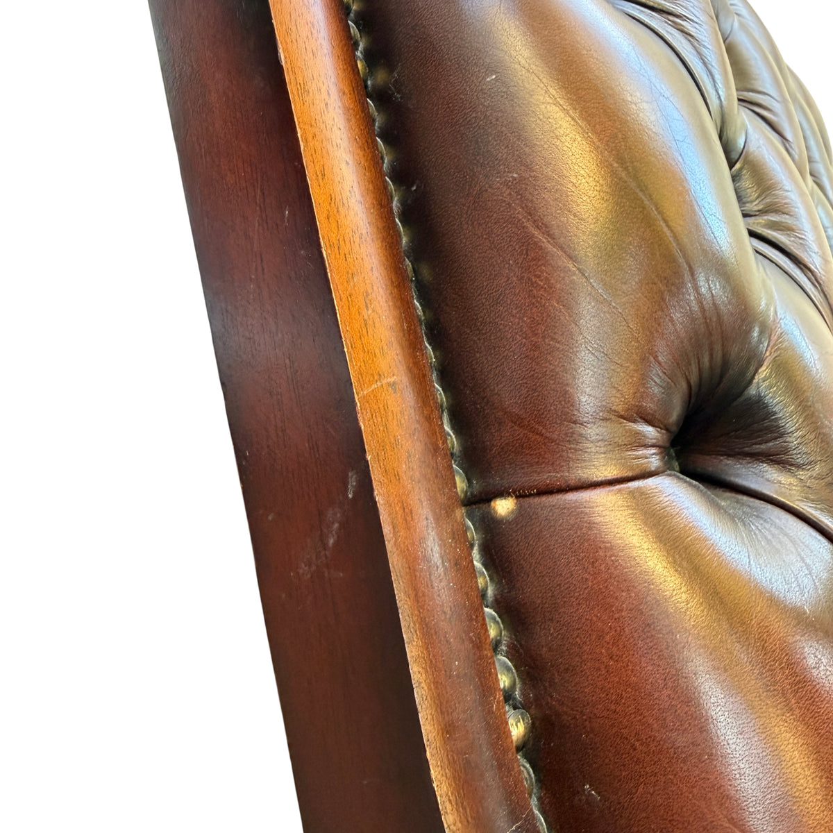 Seat and seat-front of brown tufted leather armchair with light surface wear
