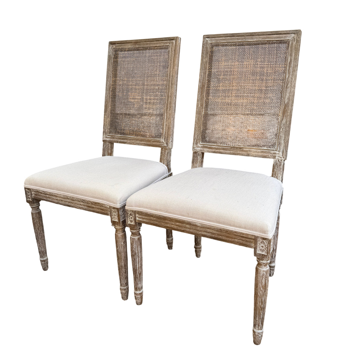 Pair of French-style dining chairs with rattan cane backs and cream upholstered seats