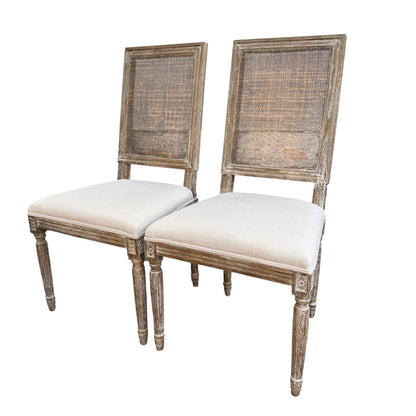 Pair of French-style dining chairs with rattan cane backs and cream upholstered seats