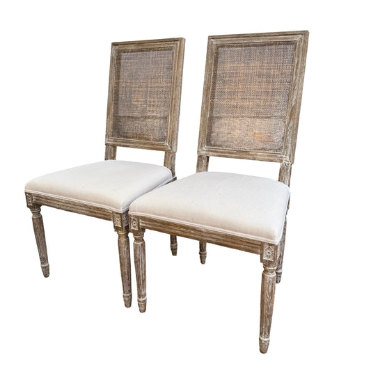Pair of French-style dining chairs with rattan cane backs and cream upholstered seats