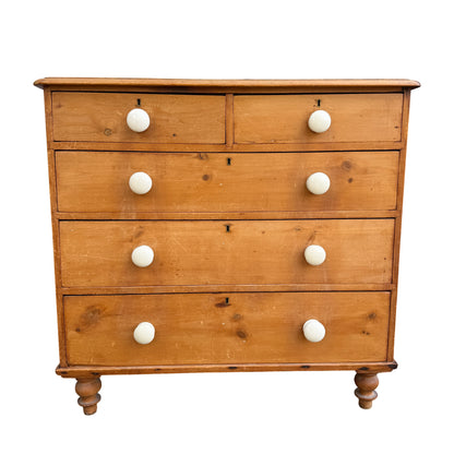Front view of Victorian pine chest of drawers with white ceramic knobs and key escutcheons