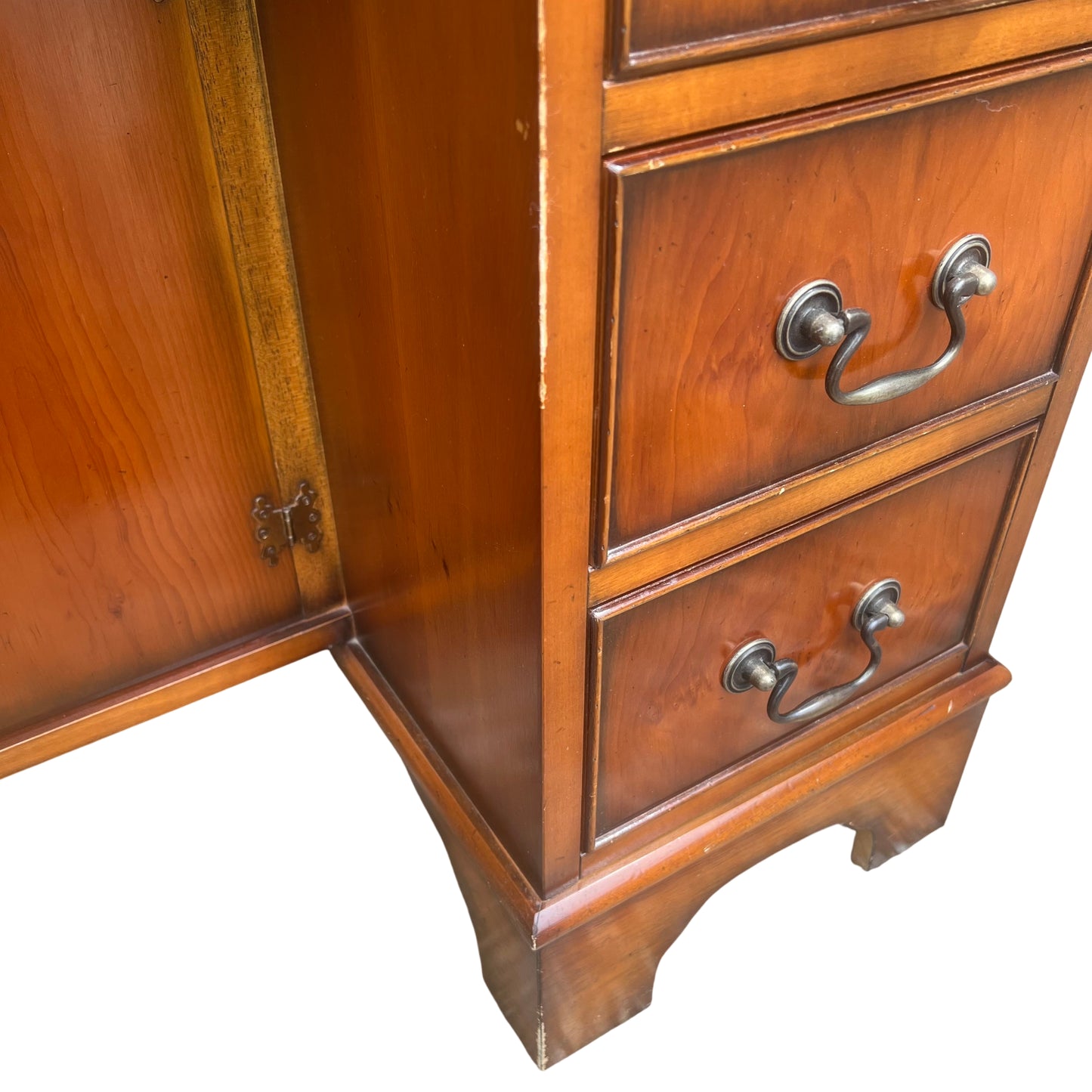 Side view of kneehole desk showing drawer arrangement and wooden finish