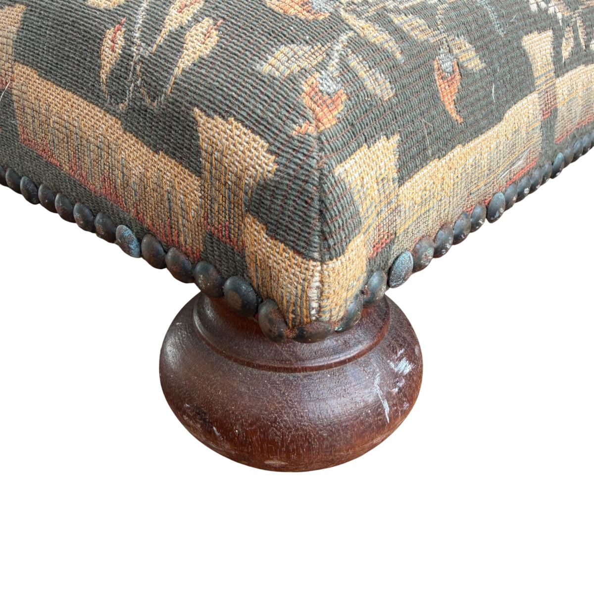 Close-up of woven tapestry upholstery with deer motif on vintage footstool