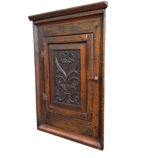 Arts & Crafts oak corner wall cabinet with carved floral panel and original latch