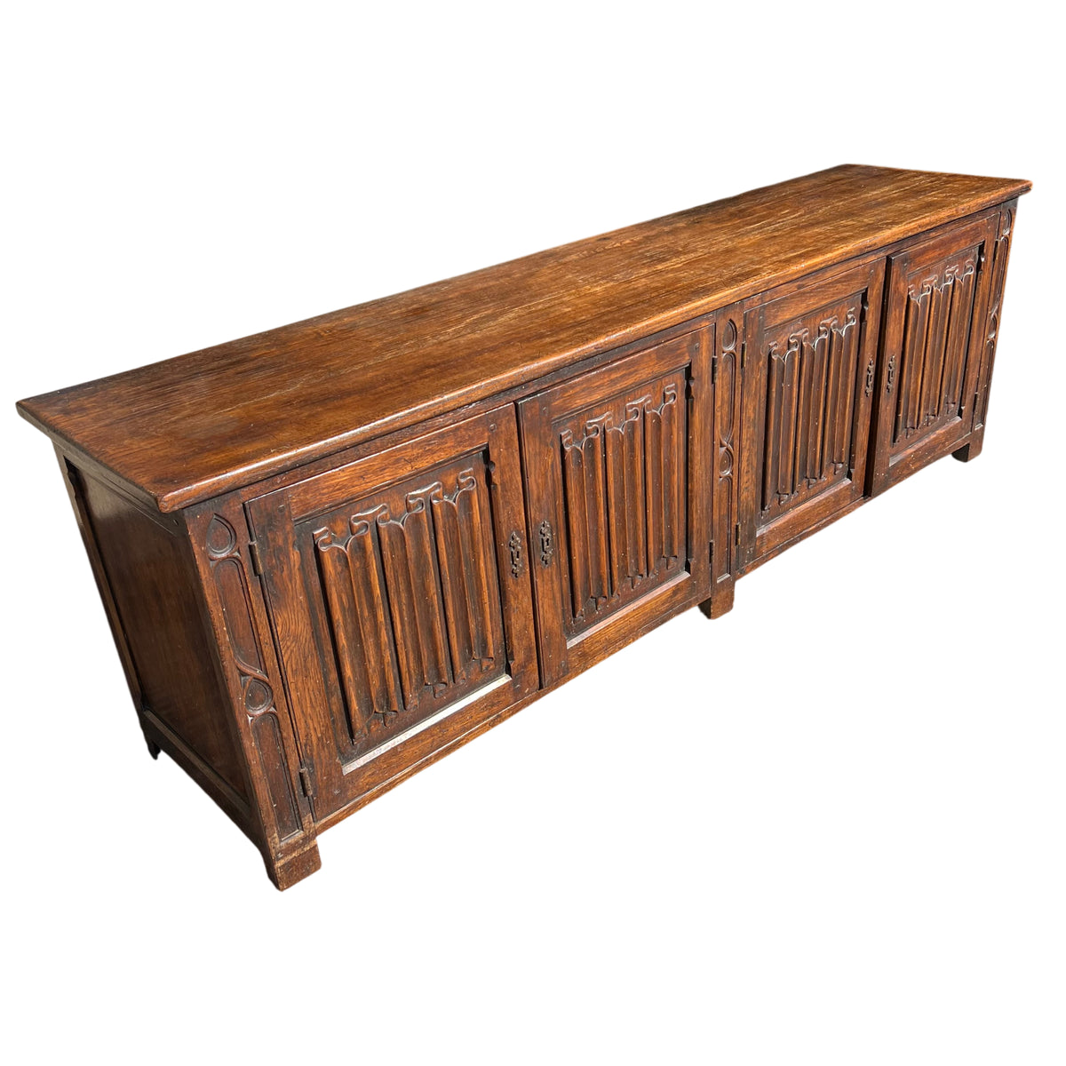 Long Victorian carved oak sideboard with Gothic tracery panels and four cupboard doors