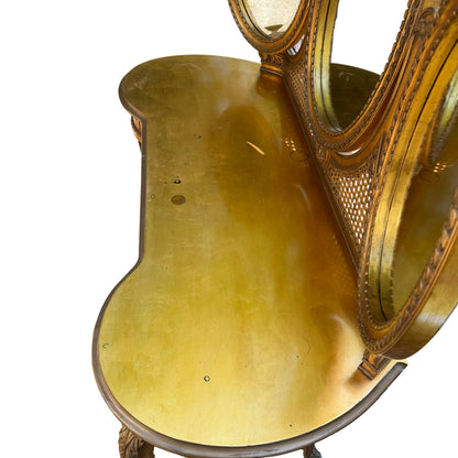 Side view of gold vanity table showing carved leg and stretcher