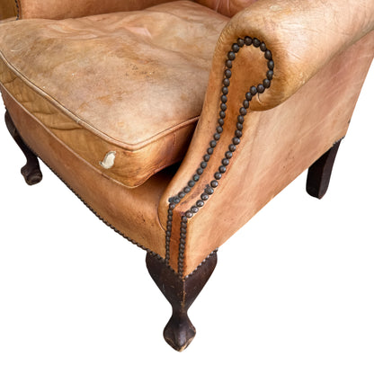 Edge of seat cushion with exposed lining where leather has ripped on a vintage armchair
