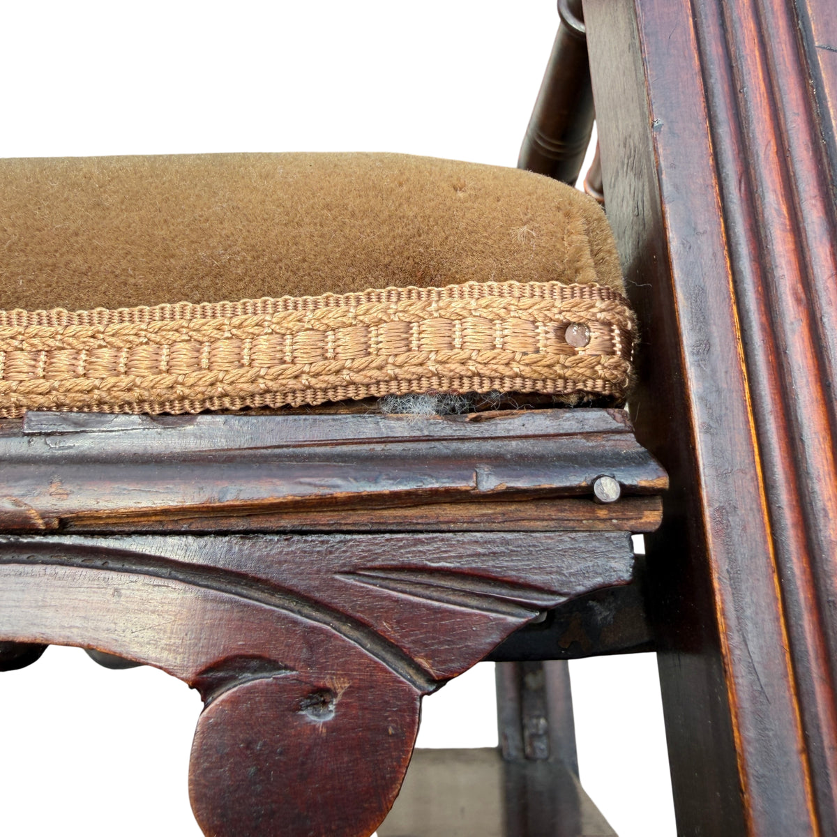 Drawer front with missing pull and decorative brass escutcheon on stool