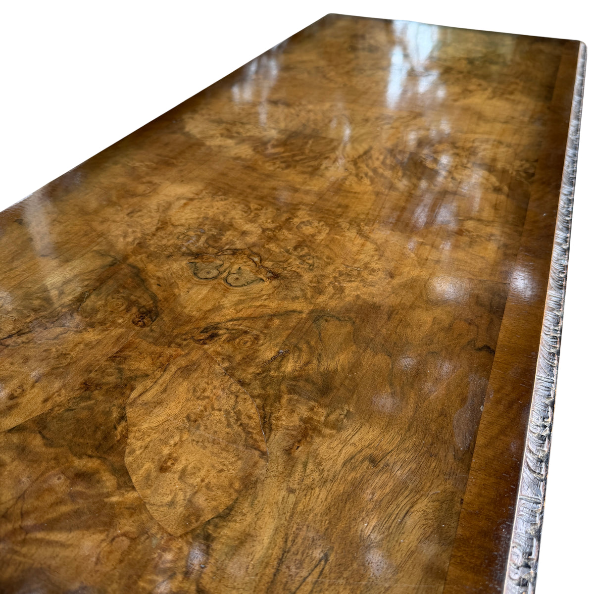 Low profile occasional table in walnut veneer with carved legs