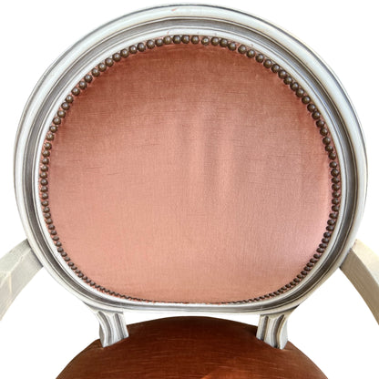 Detail of oval upholstered back with brass studs on a painted frame chair