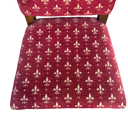 Close up of red fleur de lis patterned upholstery on a dining chair back