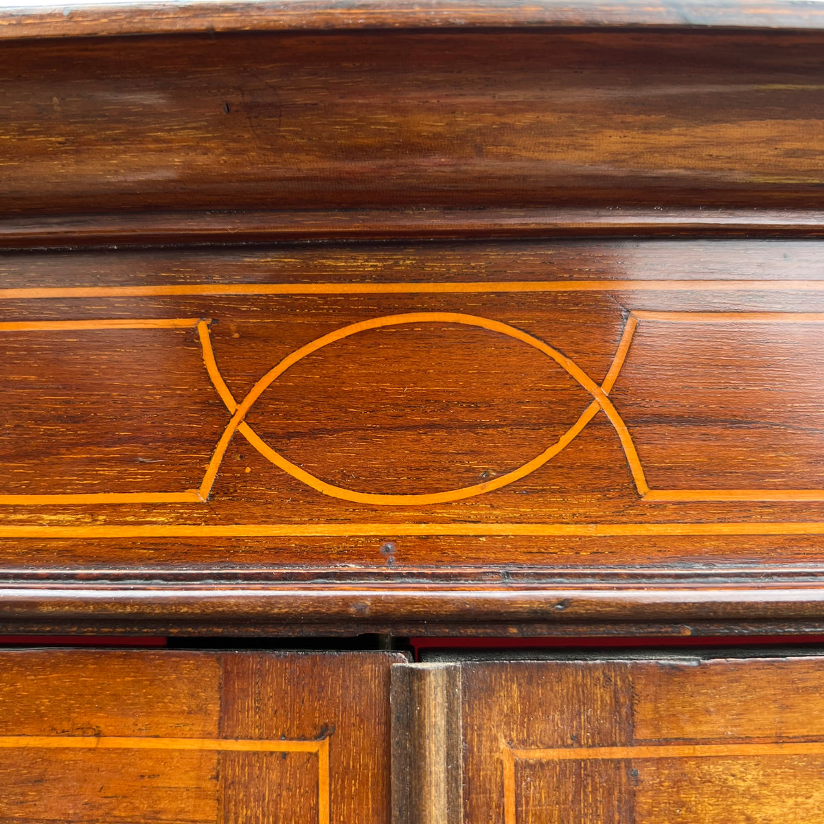 Inlaid string detail across the top of a mahogany glazed cabinet