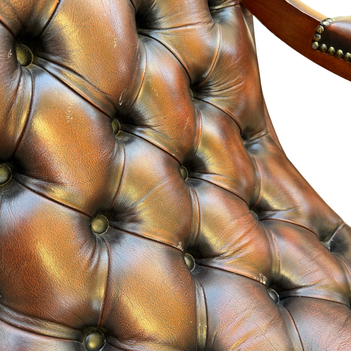 Close-up of deep-buttoned leather back and rounded buttons on armchair