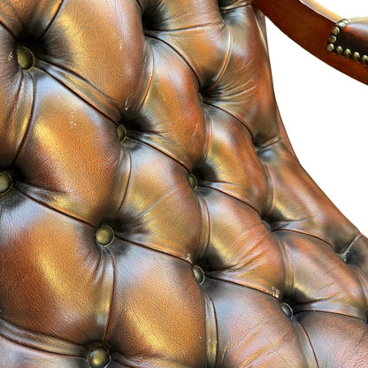 Close-up of deep-buttoned leather back and rounded buttons on armchair