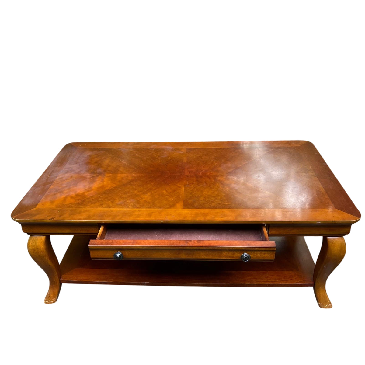 Corner of vintage coffee table showing drawer side and shaped apron